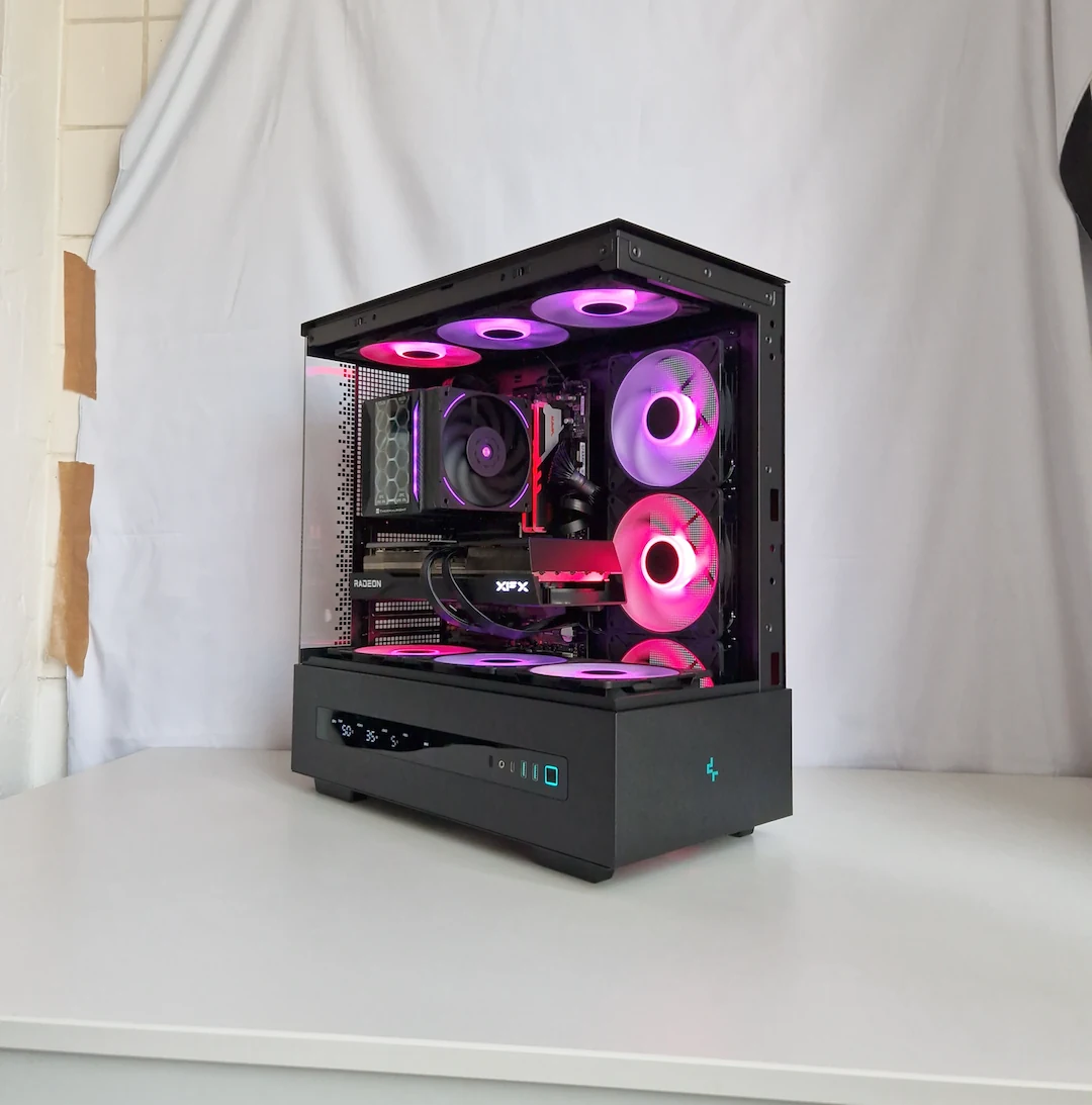 Afgeronde gaming-pc met magenta en paarse verlichting op een witte fotobackdrop